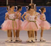 A group of young ice skaters in pink tutus